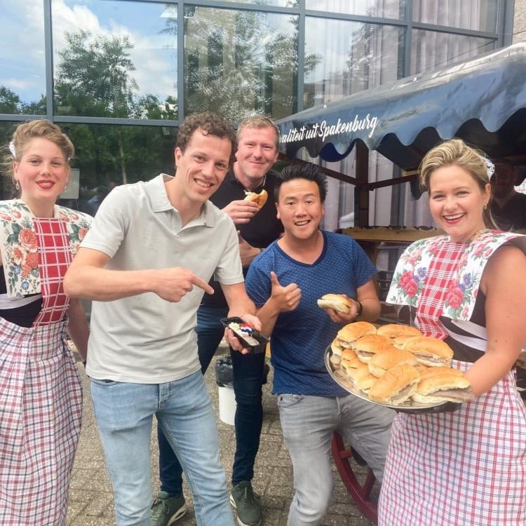 Foto van collega's met broodjes haring.