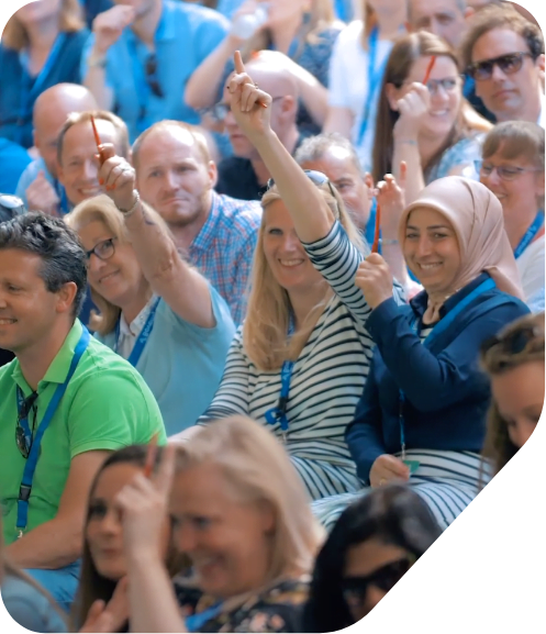 Groepje medewerkers van Bovemij die tijdens een evenement hun vinger opsteken.