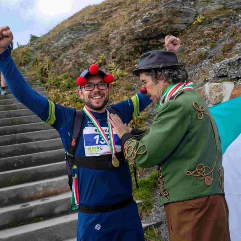 Collega Rowan ontvangt zijn medaille bij de finish van de Alpentocht.