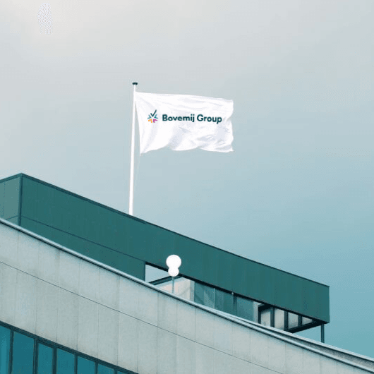Foto van Bovemij kantoorpand met wapperende vlag met logo.